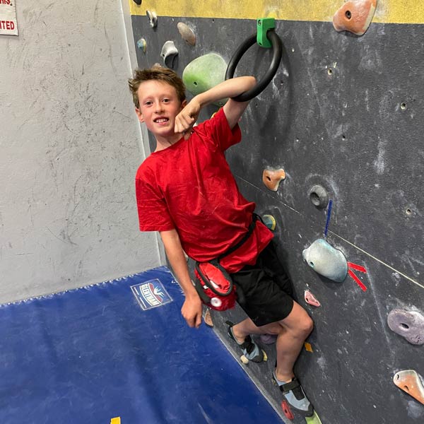 Ring clamp adaptive climbing hold being used on climbing wall by young boy